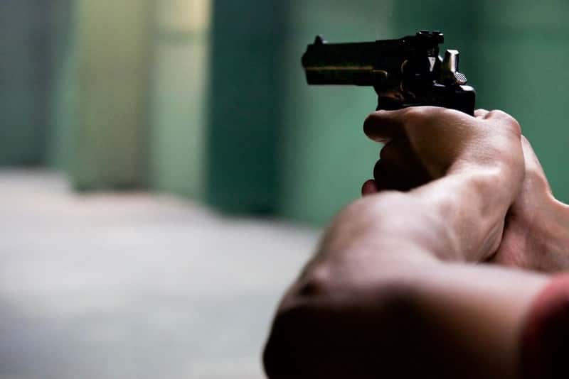 person holding gun in firing position