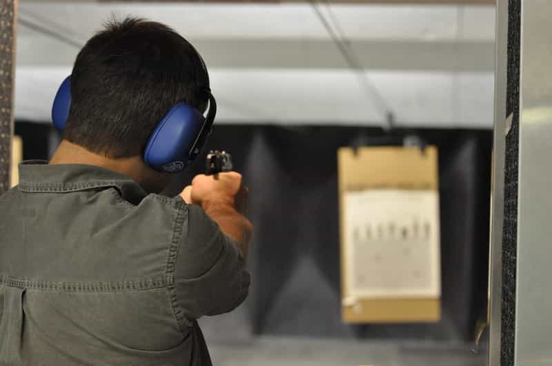 person shooting a gun at a shooting range